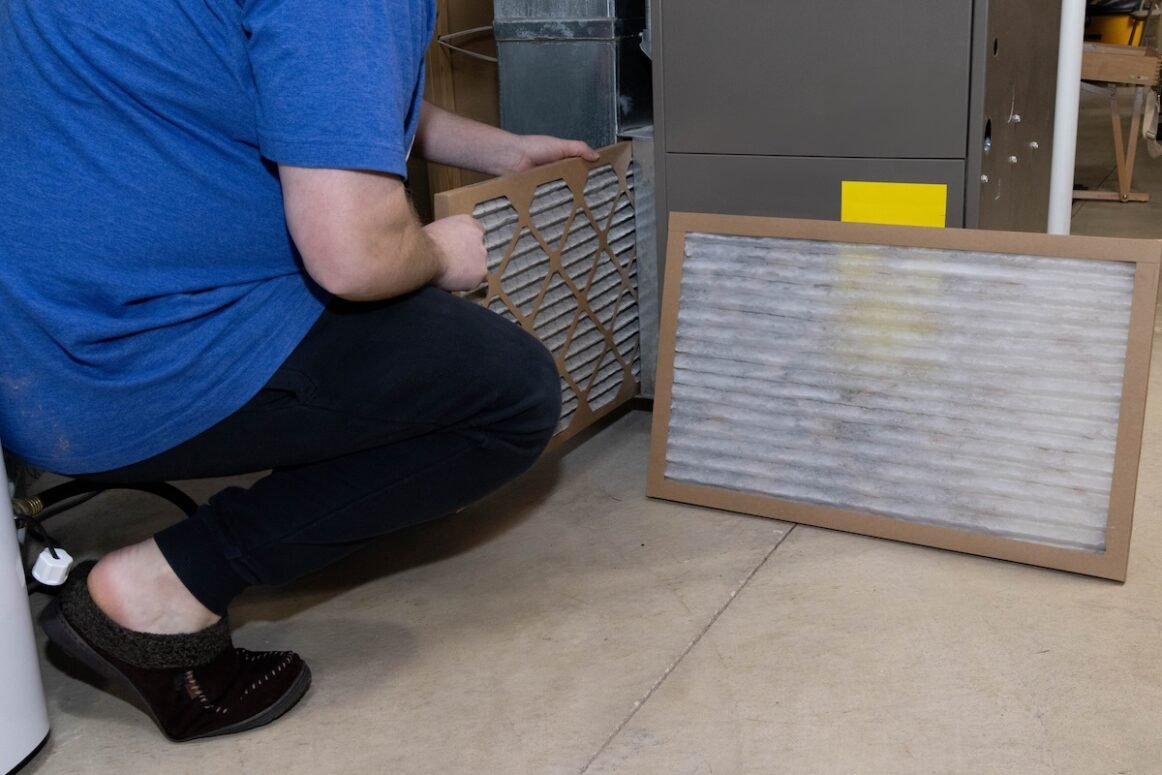 best furnace filters homeowner preforming general maintenance on home furnace, replacing the old dirty filter with a clean fresh filter for better air flow