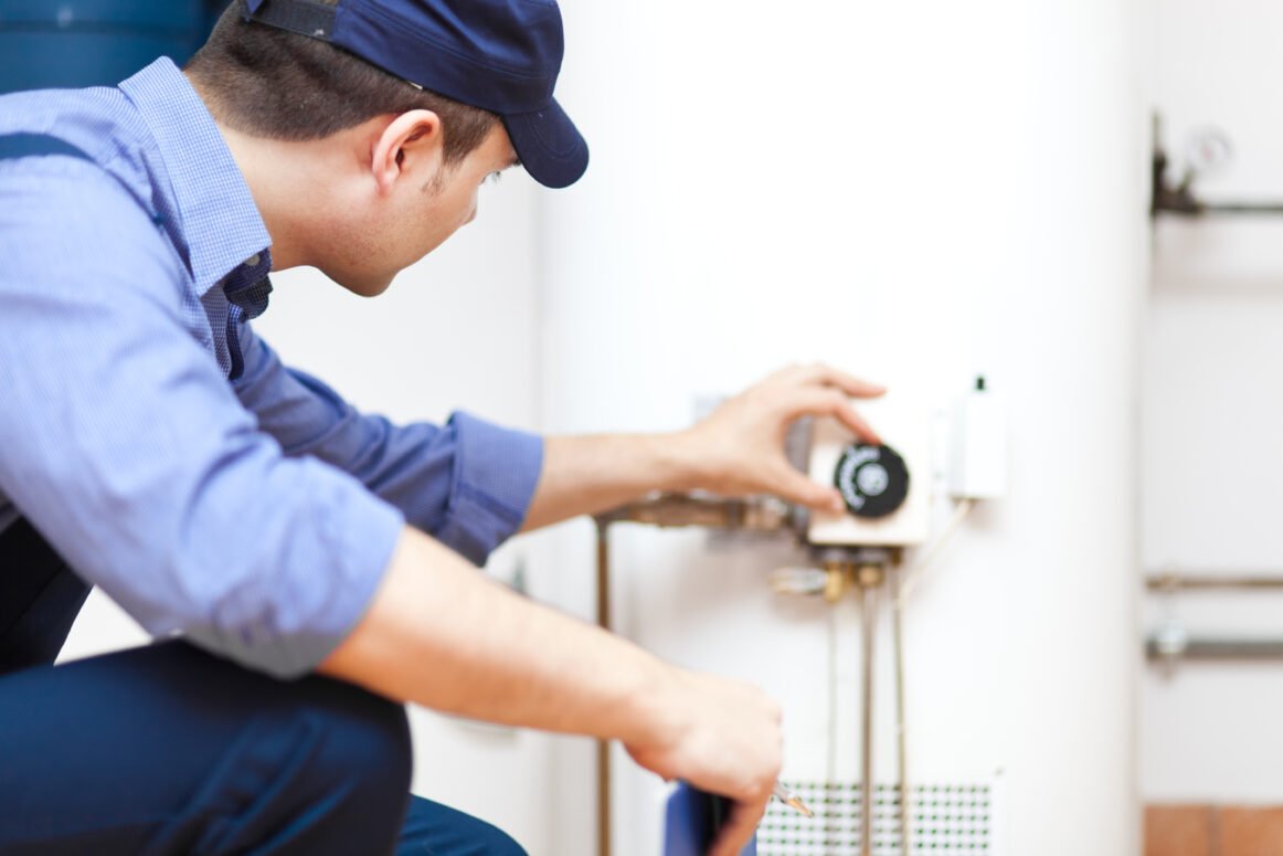 Plumber repairing an hot-water heater Plumber repairing an hot-water heater